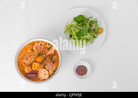 Bun Rieu Cua, Krabbenpaste Vermicelli-Suppe mit gehackten Garnelen, Tofu, Tomaten, Garnelenpaste, vietnamesisches Essen isoliert auf weißem Hintergrund, Draufsicht Stockfoto