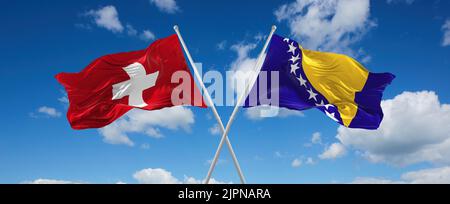 Zwei gekreuzte Flaggen Bosnien und Herzegowina und die Schweiz winken im Wind bei bewölktem Himmel. Konzept von Beziehung, Dialog, Reisen zwischen zwei Countri Stockfoto