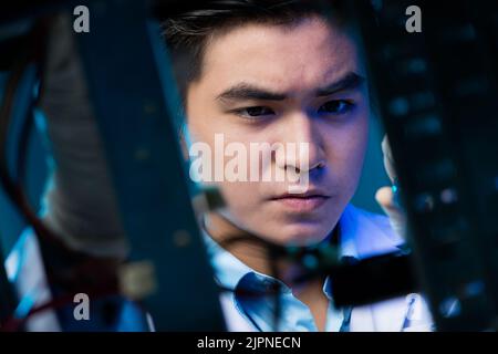 Junger asiatischer Elektronikingenieur, der an einem Roboterprojekt arbeitet Stockfoto