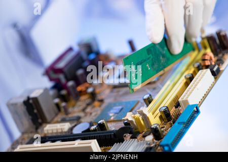 Hand der technischen Montage der elektronischen Schalttafel in den Schlitz Stockfoto