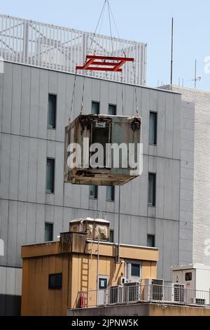 Tokio, Japan. 19. August 2022. Ein Kran trägt eine Kapsel während des Abrisses am Nakagin Capsule Tower in Ginza am 19. August 2022 in Tokio, Japan. Der Rückbau von 140 Einzelkapseln des futuristischen Gebäudes (Mischnutzung Wohn- und Büroturm) wird im Rahmen der Abbrucharbeiten bis Ende dieses Jahres fortgesetzt. Quelle: Rodrigo Reyes Marin/AFLO/Alamy Live News Stockfoto