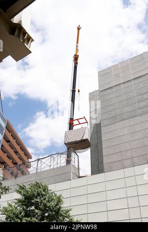 Tokio, Japan. 19. August 2022. Ein Kran trägt eine Kapsel während des Abrisses am Nakagin Capsule Tower in Ginza am 19. August 2022 in Tokio, Japan. Der Rückbau von 140 Einzelkapseln des futuristischen Gebäudes (Mischnutzung Wohn- und Büroturm) wird im Rahmen der Abbrucharbeiten bis Ende dieses Jahres fortgesetzt. Quelle: Rodrigo Reyes Marin/AFLO/Alamy Live News Stockfoto