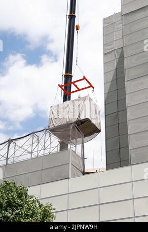 Tokio, Japan. 19. August 2022. Ein Kran trägt eine Kapsel während des Abrisses am Nakagin Capsule Tower in Ginza am 19. August 2022 in Tokio, Japan. Der Rückbau von 140 Einzelkapseln des futuristischen Gebäudes (Mischnutzung Wohn- und Büroturm) wird im Rahmen der Abbrucharbeiten bis Ende dieses Jahres fortgesetzt. Quelle: Rodrigo Reyes Marin/AFLO/Alamy Live News Stockfoto