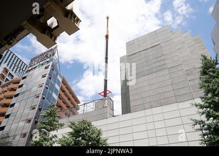 Tokio, Japan. 19. August 2022. Ein Kran trägt eine Kapsel während des Abrisses am Nakagin Capsule Tower in Ginza am 19. August 2022 in Tokio, Japan. Der Rückbau von 140 Einzelkapseln des futuristischen Gebäudes (Mischnutzung Wohn- und Büroturm) wird im Rahmen der Abbrucharbeiten bis Ende dieses Jahres fortgesetzt. Quelle: Rodrigo Reyes Marin/AFLO/Alamy Live News Stockfoto