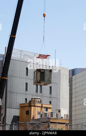 Tokio, Japan. 19. August 2022. Ein Kran trägt eine Kapsel während des Abrisses am Nakagin Capsule Tower in Ginza am 19. August 2022 in Tokio, Japan. Der Rückbau von 140 Einzelkapseln des futuristischen Gebäudes (Mischnutzung Wohn- und Büroturm) wird im Rahmen der Abbrucharbeiten bis Ende dieses Jahres fortgesetzt. Quelle: Rodrigo Reyes Marin/AFLO/Alamy Live News Stockfoto