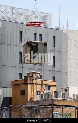 Tokio, Japan. 19. August 2022. Ein Kran trägt eine Kapsel während des Abrisses am Nakagin Capsule Tower in Ginza am 19. August 2022 in Tokio, Japan. Der Rückbau von 140 Einzelkapseln des futuristischen Gebäudes (Mischnutzung Wohn- und Büroturm) wird im Rahmen der Abbrucharbeiten bis Ende dieses Jahres fortgesetzt. Quelle: Rodrigo Reyes Marin/AFLO/Alamy Live News Stockfoto