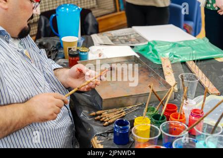 Der Künstler Tugay Yalcin unterrichtet Anfänger in der Fenham Library, Newcastle upon Tyne, Großbritannien, die Kunst des Papiermarbling, einer türkischen Disziplin, die als ebru bekannt ist. Stockfoto