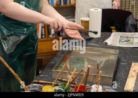 Der Künstler Tugay Yalcin unterrichtet Anfänger in der Fenham Library, Newcastle upon Tyne, Großbritannien, die Kunst des Papiermarbling, einer türkischen Disziplin, die als ebru bekannt ist. Stockfoto