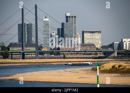 Rhein bei Düsseldorf, extrem niedriges Wasser, Rheinhöhe 47 cm, fallender Trend, Barge vor der Skyline mit Rheinneibrücke, Sandba Stockfoto