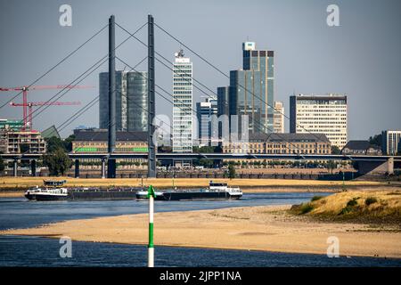 Rhein bei Düsseldorf, extrem niedriges Wasser, Rheinhöhe 47 cm, fallender Trend, Barge vor der Skyline mit Rheinneibrücke, Sandba Stockfoto