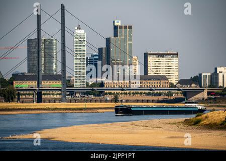 Rhein bei Düsseldorf, extrem niedriges Wasser, Rheinhöhe 47 cm, fallender Trend, Barge vor der Skyline mit Rheinneibrücke, Sandba Stockfoto