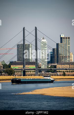 Rhein bei Düsseldorf, extrem niedriges Wasser, Rheinhöhe 47 cm, fallender Trend, Barge vor der Skyline mit Rheinneibrücke, Sandba Stockfoto