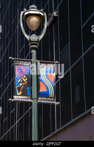 Milwaukee, WI, USA April 10 2022: River Walk-Banner auf dem Leuchtpfosten in der Innenstadt von Milwaukee, Wisconsin. Dies ist eine beliebte Gegend zum Spaziergehen mit Restaurant Stockfoto