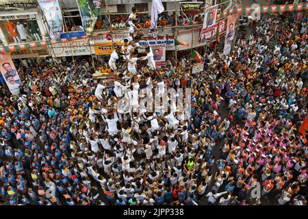 Mumbai, Indien. 19. August 2022. Hinduistische Anhänger bilden eine menschliche Pyramide, um Dahi handi (irdischer Topf mit Quark gefüllt) während des Janmashtami-Festivals in Mumbai zu brechen. Janmashtami wird gefeiert, um die Geburt von Lord Krishna zu markieren. Hinduistische Anhänger versammeln sich auf den Straßen und bilden akrobatische Pyramiden, um Dahi handi (irdischer Topf mit Quark gefüllt) zu brechen, um den Anlass zu feiern. Kredit: SOPA Images Limited/Alamy Live Nachrichten Stockfoto