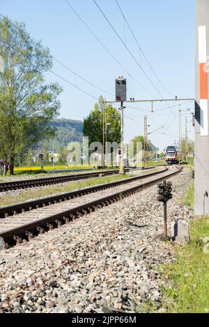 Nendeln, Liechtenstein, 28. April 2022 der Regionalzug aus Österreich kommt zu einem kleinen Bahnhof an Stockfoto