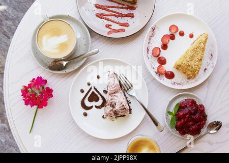 Auswahl an natürlichen veganen, geschichteten Desserts, Stück Kuchen mit frischen Früchten und Beeren. Feier, Auswahl an Kuchen auf der Terrasse. Essen von oben. Stockfoto