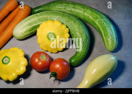 Eine Vielzahl von frischem Gemüse, direkt aus dem heimischen Garten, einschließlich Gurken, Karotten und Kürbis. Stockfoto