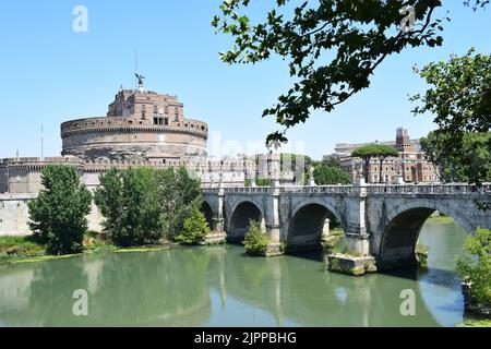 ROM, ITALIEN - 21. JULI 2022: Blick auf den Tiber und die Brücke Ponte Sant'Angelo. Das Mausoleum von Hadrian, auch bekannt als Castel Sant'Angelo, auf der rechten Seite. Stockfoto
