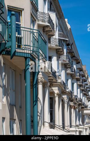 Reihe oder Terrasse von historischen Häusern in der küstenstadt hastings in kent, viktorianische Terrassen in der Küstenstadt mit Erkerfenstern und Geländern. Stockfoto