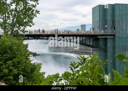 Niagarafälle, NY - 31. Juli 2022: Blick auf die im Nebel gehüllten Niagarafälle, eingerahmt von der Brücke, die zur Aussichtsplattform und zu den Bäumen führt. Stockfoto