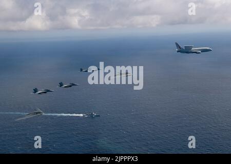 Während einer Bomber Task Force Mission fliegen zwei U.S. Air Force B-2 Spirits neben vier Royal Australian Air Force EA-18G Growlers und einer RAAF E-7A Wedgetail, während der Royal Australian Navy Hobart Class Lenkraketen-Zerstörer HMAS Brisbane (ll) am 4. August 2022 an der Ostküste Australiens segelt. Bilaterale Ausbildungsmissionen verbessern die gemeinsame und multilaterale Bereitschaft, so dass das US-Kommando für den Indo-Pazifik-Raum auf jede mögliche Krise in der Region gemeinsam mit Alliierten und Partnern reagieren kann, um einen freien und offenen Indo-Pazifik-Raum zu unterstützen. (USA Navy Foto von LT. Cmdr. Andrew Bishline) Stockfoto