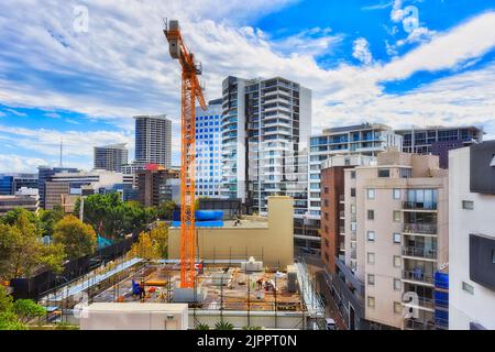 Hochhaus-Wohnapartmentgebäude, das im Vorort Lower North Shore von Sydney mit Kran, Ausrüstung und Arbeitern auf einem Dach mit Gerüst errichtet wurde Stockfoto