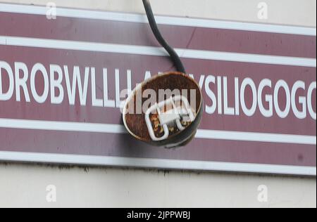 EIN ROSTIGES LICHT HÄNGT ÜBER DEM BERÜHMTEN SCHILD AN DER BAUFÄLLIGEN STATION MIT DEM LÄNGSTEN NAMEN DER WELT AN DER LLANFAIRPWLGWYNGYLLGOGERYCHWYRNDROBWLLLLANTYSILIOGOGOGOGOCH, IN NORDWALES PIC MIKE WALKER,2011 Stockfoto