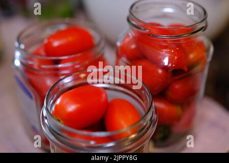 Hausgemachte eingelegte Tomaten in Gläsern fermentierte Tomaten in transparentem Glas. Hausgemachte Tomaten aus der Dose Stockfoto