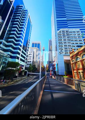 Eine vertikale Aufnahme von hohen Wolkenkratzern mit blauen Glaswänden, die über den Straßen von Sydney, Australien, ragen Stockfoto