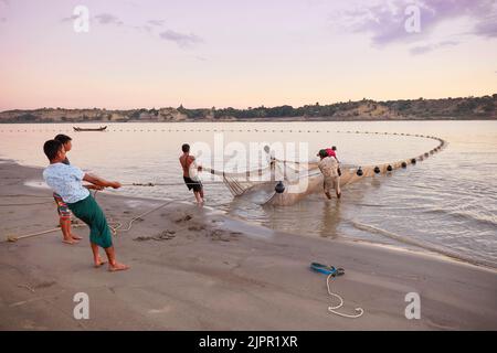 Eine Gruppe von Fischern erhebt das Fischernetz am Irrawaddy River in der Abenddämmerung, Nyaung U, Bagan, Birma. Stockfoto