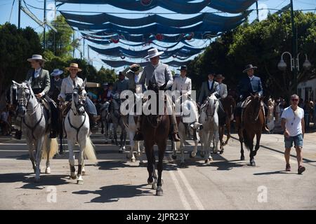 Eine Gruppe von Reitern wird beim Reiten gesehen, während sie an der Messe Málaga 2022 auf der Messe 'Cortijo de Torres' teilnehmen. Nach zwei Jahren Annullierung aufgrund der Coronavirus-Pandemie versammeln sich Tausende von Menschen in den Hauptstraßen der Stadt, um in festlicher Stimmung an der Messe von Malaga teilzunehmen. In einer Woche werden Tausende von Touristen und Einheimischen Konzerte, Flamenco-Tänze auf den Straßen und andere Aktivitäten wie die Stierkampfmesse oder Pferdeshows genießen. Stockfoto