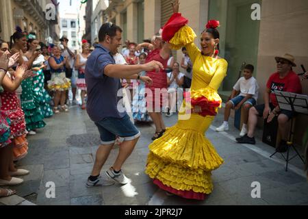 Malaga, Spanien. 19. August 2022. Ein Paar wird beim Flamenco-Tanz auf der Straße gesehen, während sie an der Messe Málaga 2022 in der Marques de Larios Straße teilnehmen. Nach zwei Jahren Annullierung aufgrund der Coronavirus-Pandemie versammeln sich Tausende von Menschen in den Hauptstraßen der Stadt, um in festlicher Stimmung an der Messe von Malaga teilzunehmen. In einer Woche werden Tausende von Touristen und Einheimischen Konzerte, Flamenco-Tänze auf den Straßen und andere Aktivitäten wie die Stierkampfmesse oder Pferdeshows genießen. (Bild: © Jesus Merida/SOPA Images via ZUMA Press Wire) Stockfoto