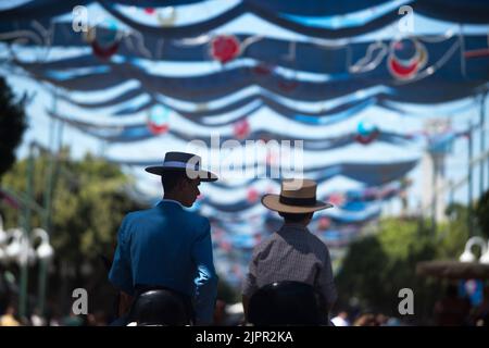 Malaga, Spanien. 19. August 2022. Ein paar Teenager werden auf Pferden gesehen, als sie an der Messe Málaga 2022 auf der Messe 'Cortijo de Torres' teilnehmen. Nach zwei Jahren Annullierung aufgrund der Coronavirus-Pandemie versammeln sich Tausende von Menschen in den Hauptstraßen der Stadt, um in festlicher Stimmung an der Messe von Malaga teilzunehmen. In einer Woche werden Tausende von Touristen und Einheimischen Konzerte, Flamenco-Tänze auf den Straßen und andere Aktivitäten wie die Stierkampfmesse oder Pferdeshows genießen. (Foto von Jesus Merida/SOPA Images/Sipa USA) Quelle: SIPA USA/Alamy Live News Stockfoto