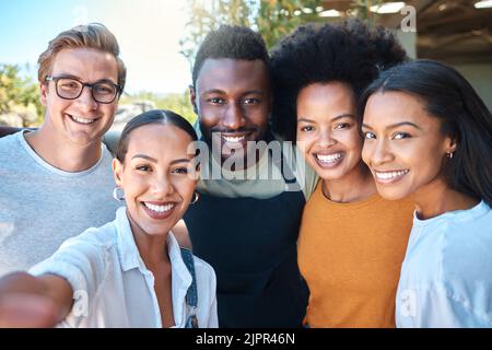 Porträt diverser Freunde, die ein Selfie machen, sich verbinden und gemeinsam ihre Freiheit im Freien genießen. Junge Gruppe, die Spaß hat, lächelt und glücklich aussieht Stockfoto