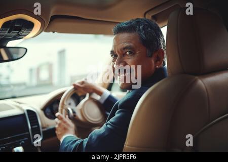 Sind Sie bereit für eine reibungslose Fahrt. Ein reifer Geschäftsmann fahren ein stilvolles Auto. Stockfoto