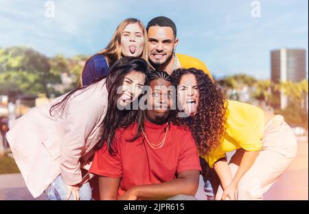 Multikulturelle Freunde nehmen verrücktes Selfie und ragen aus der Zunge - Junge Menschen, die Spaß miteinander haben Stockfoto