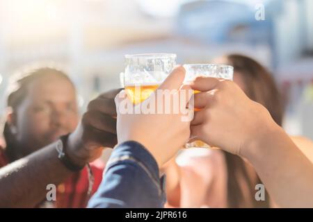 Fröhliche Leute, die draußen an der Brauerei-Bar mit Bier toasten - Junge Freunde, die gemeinsam Spaß an der Happy Hour haben - konzentrieren sich auf Glas Stockfoto