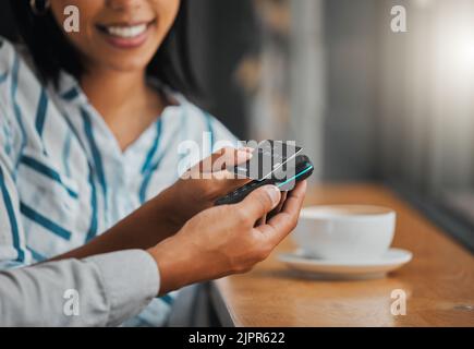 Man zahlt die Rechnung mit der Kreditkarte für Kaffee oder Tee im Café, Café oder Restaurant aus nächster Nähe. Frau macht bargeldlosen Kauf mit Hilfe und Stockfoto