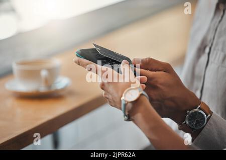 Kontaktloses Bezahlen, NFC-Technologie und Antippen einer Bank oder Kreditkarte für die Zahlung in einem Café, Café oder kleinen Unternehmen. Kunde kauft oder Stockfoto