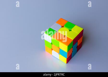 Ungelöster rubik Zauberwürfel auf weißem, isoliertem Hintergrund Stockfoto