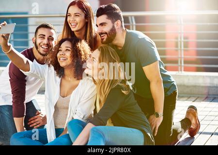 Kommen Sie herein für das Selfie. Junge Freunde machen ein Selfie draußen. Stockfoto