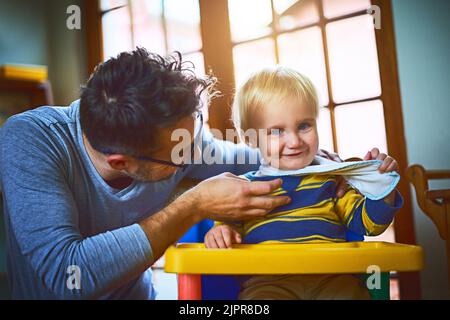 Es gibt immer Zeit für ein paar Kitzeln. Ein alleinerziehender Vater kitzelt seinen Sohn zu Hause. Stockfoto