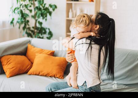 Mama umarmt und beruhigt ein weinendes Kind Stockfoto