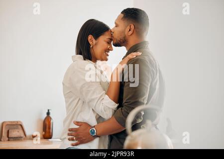 Küssende, entspannte und romantische Paar genießen Liebe, Bindung und besonderen Moment zusammen zu Hause. Fürsorglicher Ehemann und Ehefrau in einer liebevollen Beziehung Stockfoto