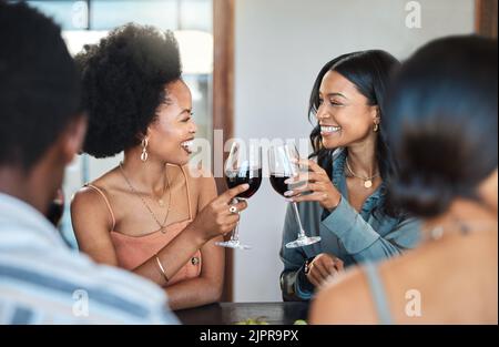 Freunde haben Spaß und trinken Wein, Toasten, Kleben und feiern auf einer Veranstaltung oder Party. Diverse Freunde jubeln und lachen, genießen Freizeit Stockfoto
