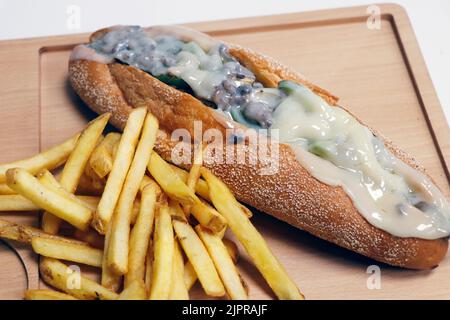 philly-Käse-Sandwich mit angus-Rind und Provolone-Käse, serviert mit Kartoffelchips Stockfoto