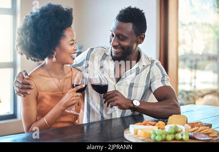 Junges Paar feiert mit Wein und Jubel im Resort, lacht und freundet sich an einem romantischen Date. Sorglos, verliebt schwarze Freundin und Freund toasten Stockfoto