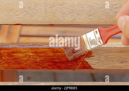 Eine Holzoberfläche, die eine rote Holzbeschichtung erhält, durchdringendes Öl transparent. Stockfoto