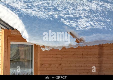 Ein Eisblock hängt vom Dach des Hauses Stockfoto