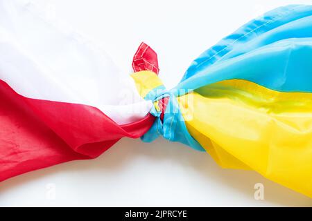 Die polnische Flagge und die ukrainische Flagge sind auf weißem Hintergrund geknüpft, ein Bündnis zwischen den beiden Ländern während des Ukraine-Krieges Stockfoto